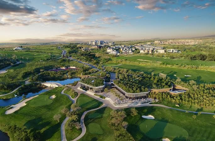 Aerial view of a golf clubhouse set among fairways and water in Gauteng